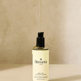 Aesthetic product shot of Blossera Belly Oil with oil dripping to show lightweight, nourishing texture.